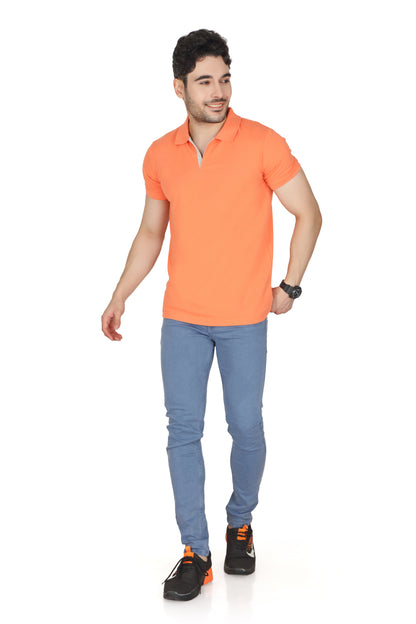 Man wearing an orange polo shirt and blue jeans on a white background