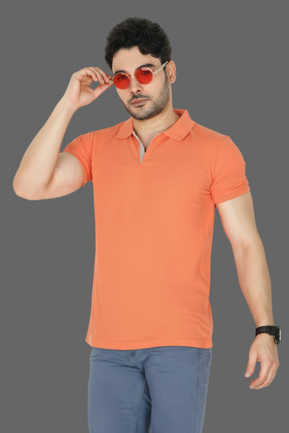 Man wearing an orange polo shirt and blue pants on a gray background